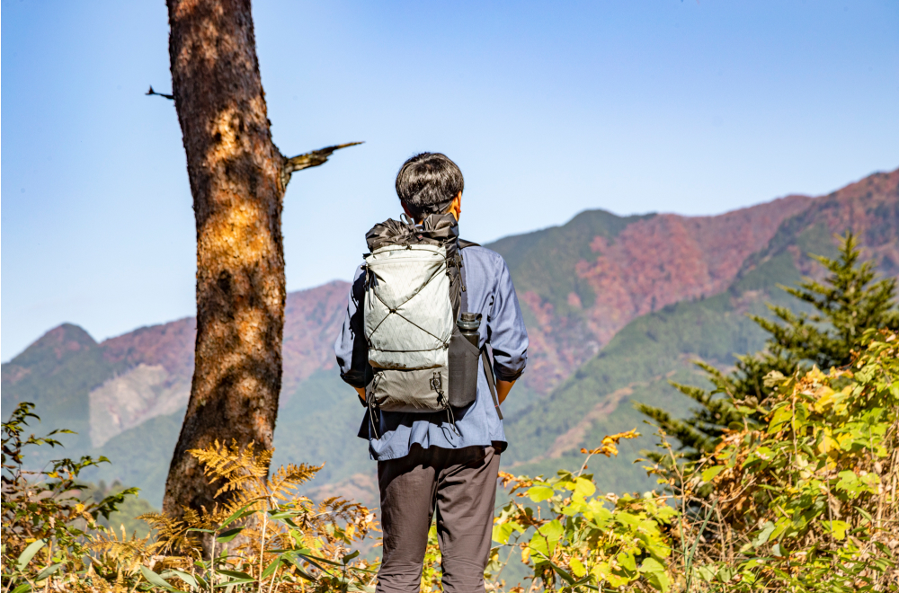 開けた登山道から山を眺めるJINさん