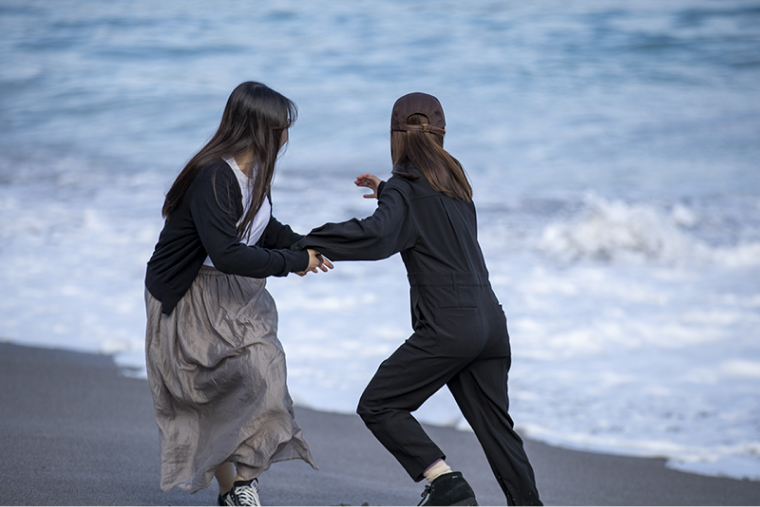 「どこまで波に近づけるかゲーム」を楽しむアオイさんとエリナさん