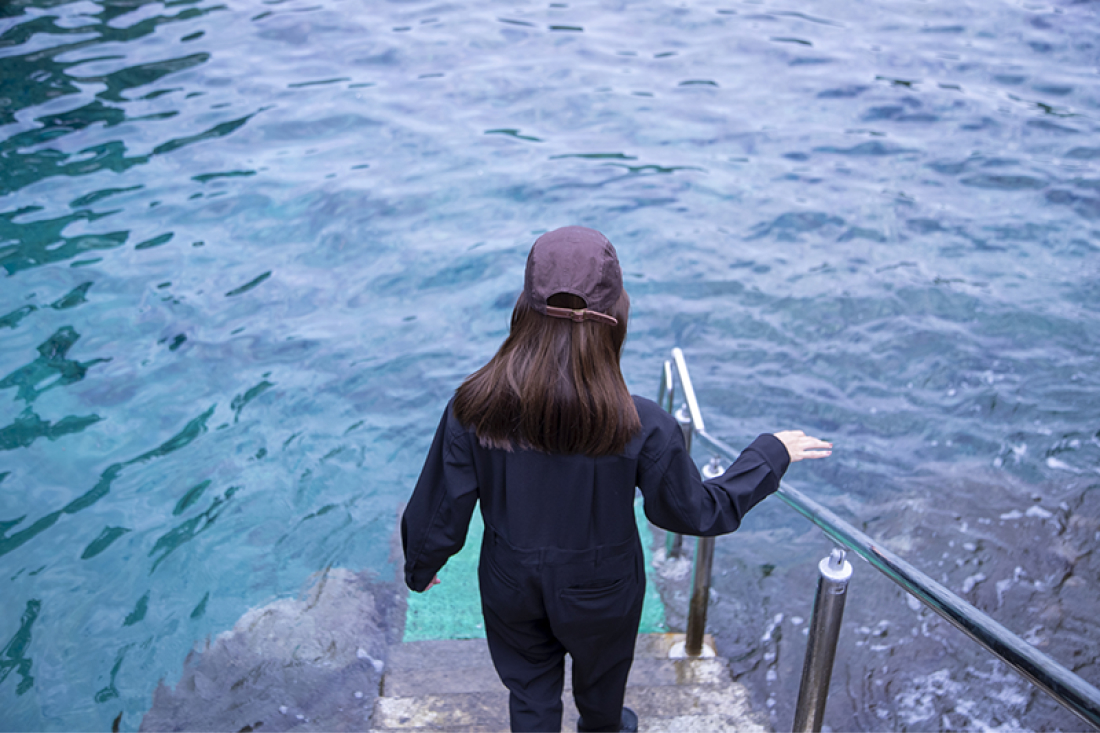 海へ降りる階段をぎりぎりまで降りるアオイさん