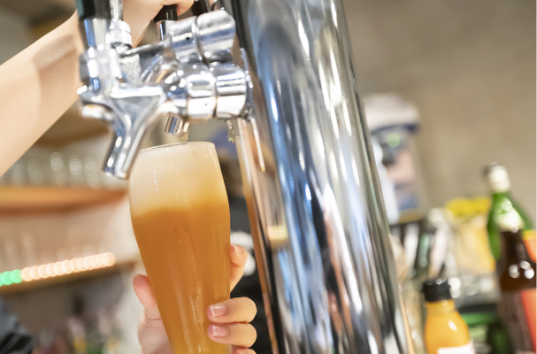 サーバーでグラスにクラフトビールを注ぐ様子
