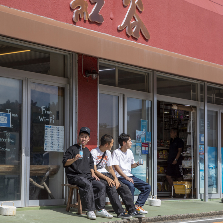 お店の前のベンチに腰掛けサイダーを飲む3人
