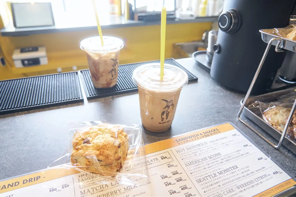 黄色いストローがささった透明なプラスチックカップに入ったドリンクと袋入りのアメリカンスコーン