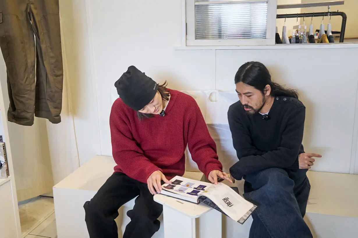 店内に置いてるヒップホップのビンテージTシャツ本に目を通す二人