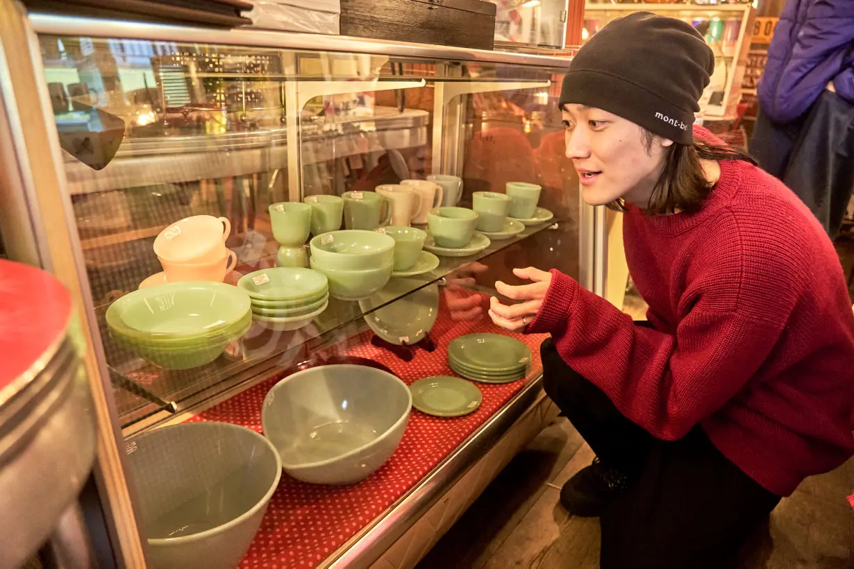 グリーン系の色合いが美しい食器が並ぶ棚に夢中のハルキさん