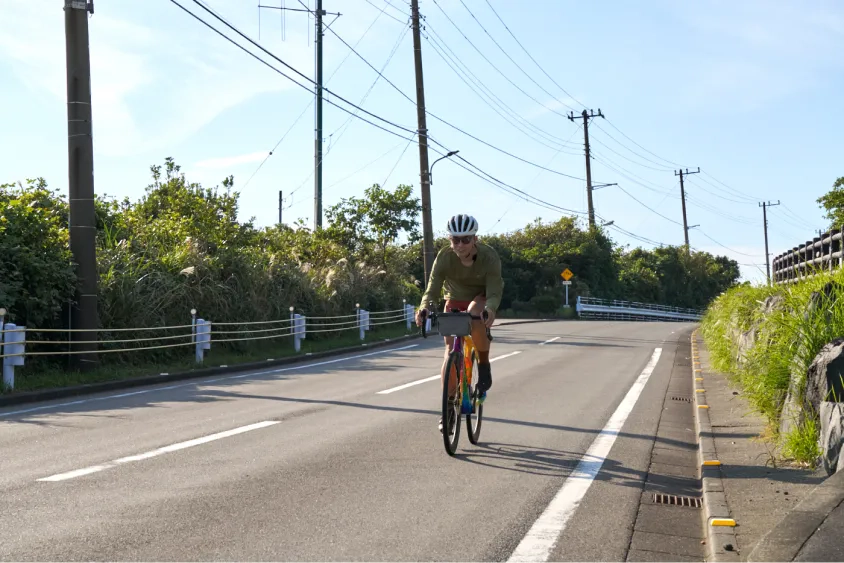ロードバイクで道路を走るけんたさん
