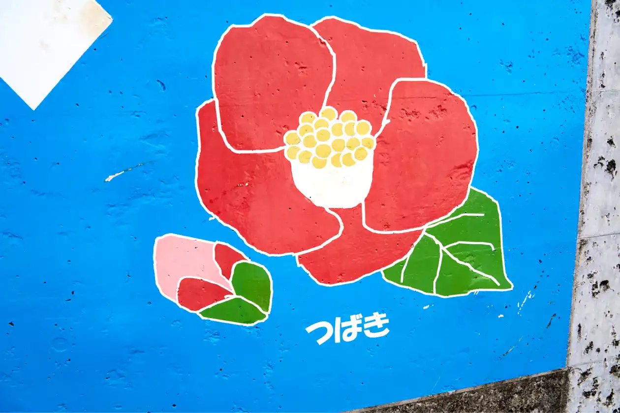 利島の船着場のブロック塀に椿のイラスト