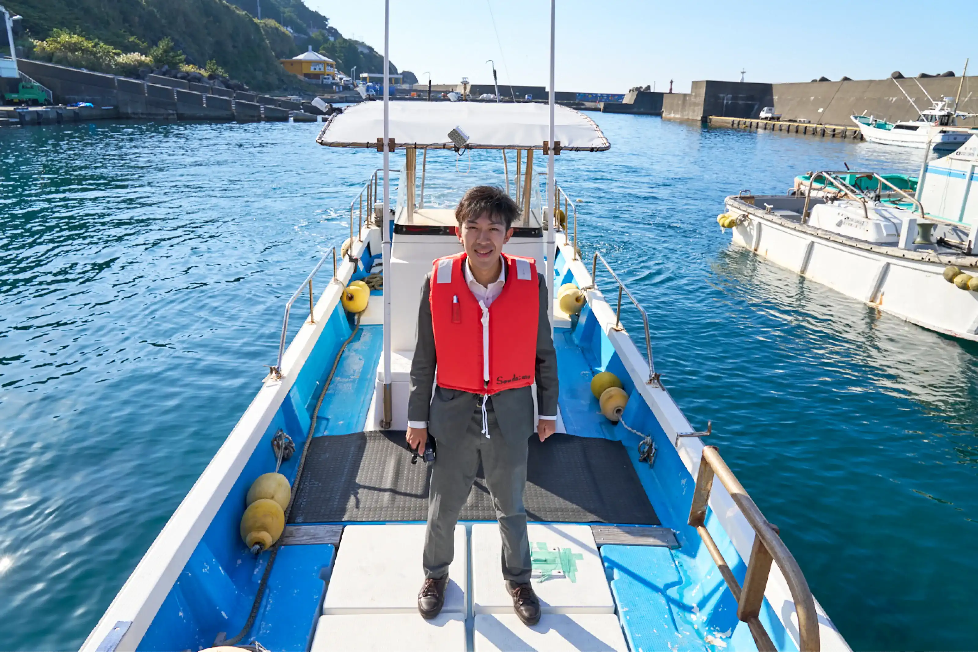 漁船の上に立っているスーツさん