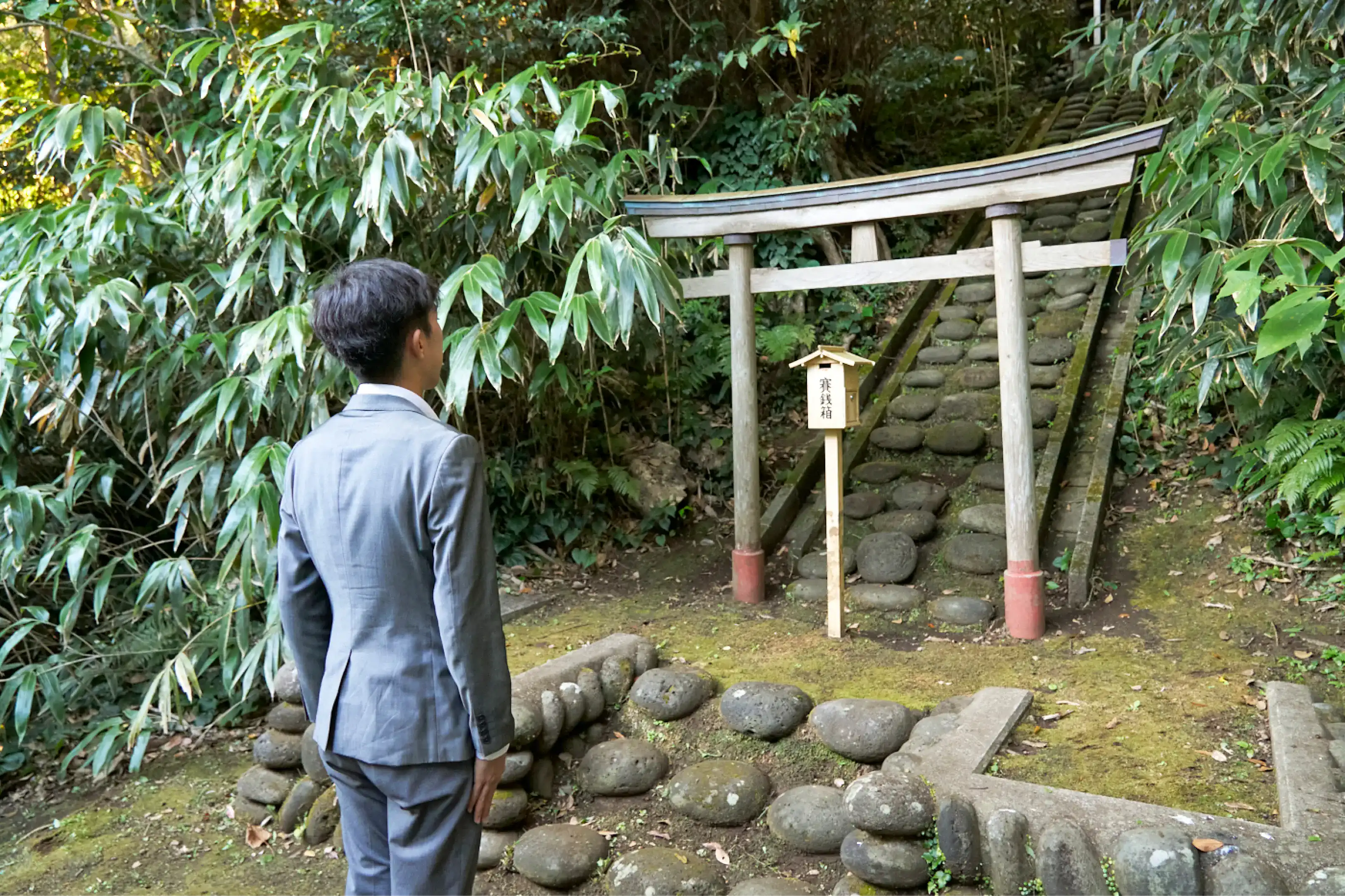 阿豆佐和気命神社本宮の前に立つスーツさん
