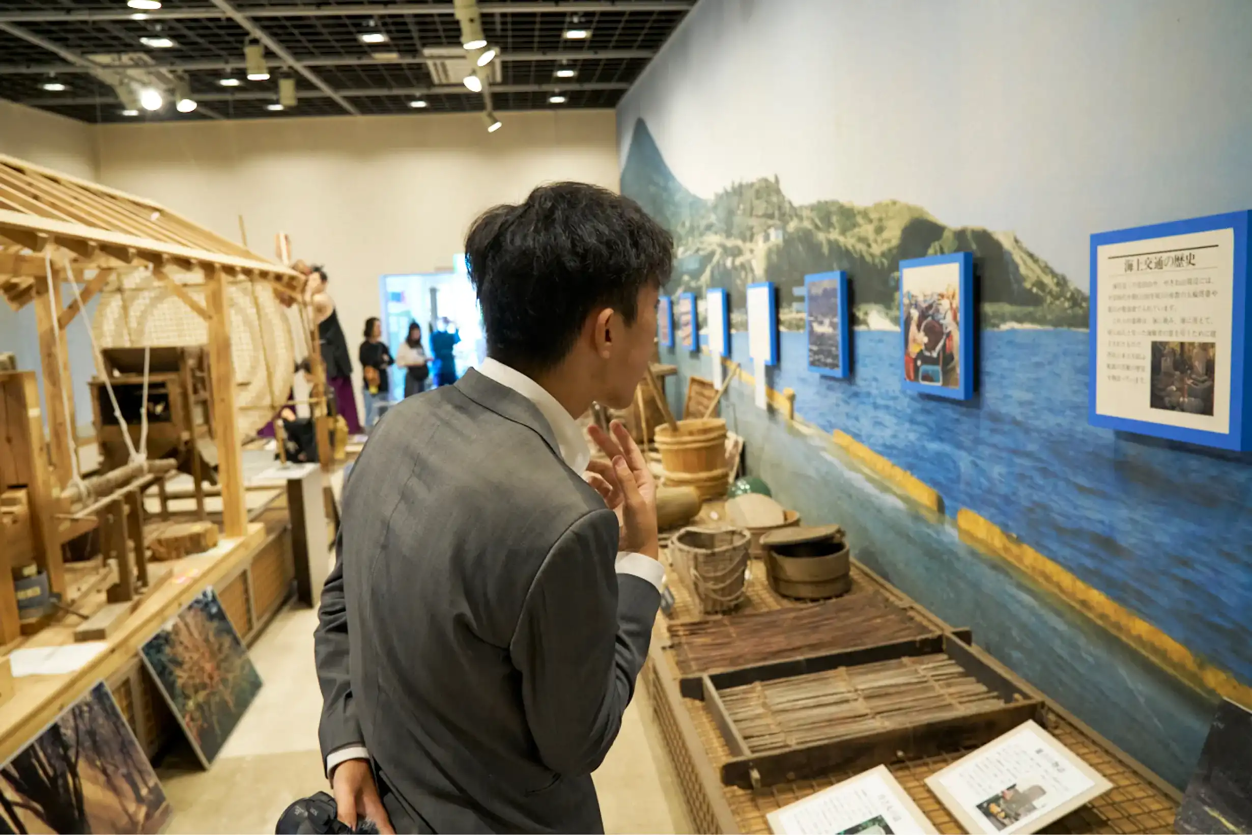 展示物を見るスーツさん