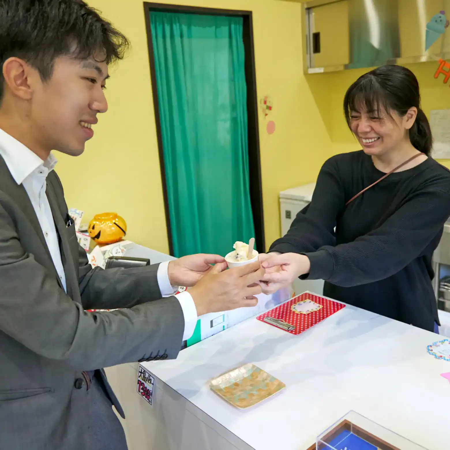 ラムレーズン味のジェラートを受け取るスーツさん